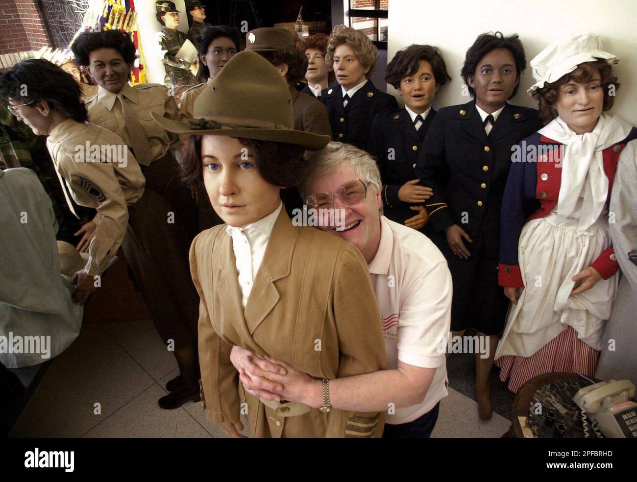 Museum technician Jackie Wolfe, hugs one of her mannequins dressed in