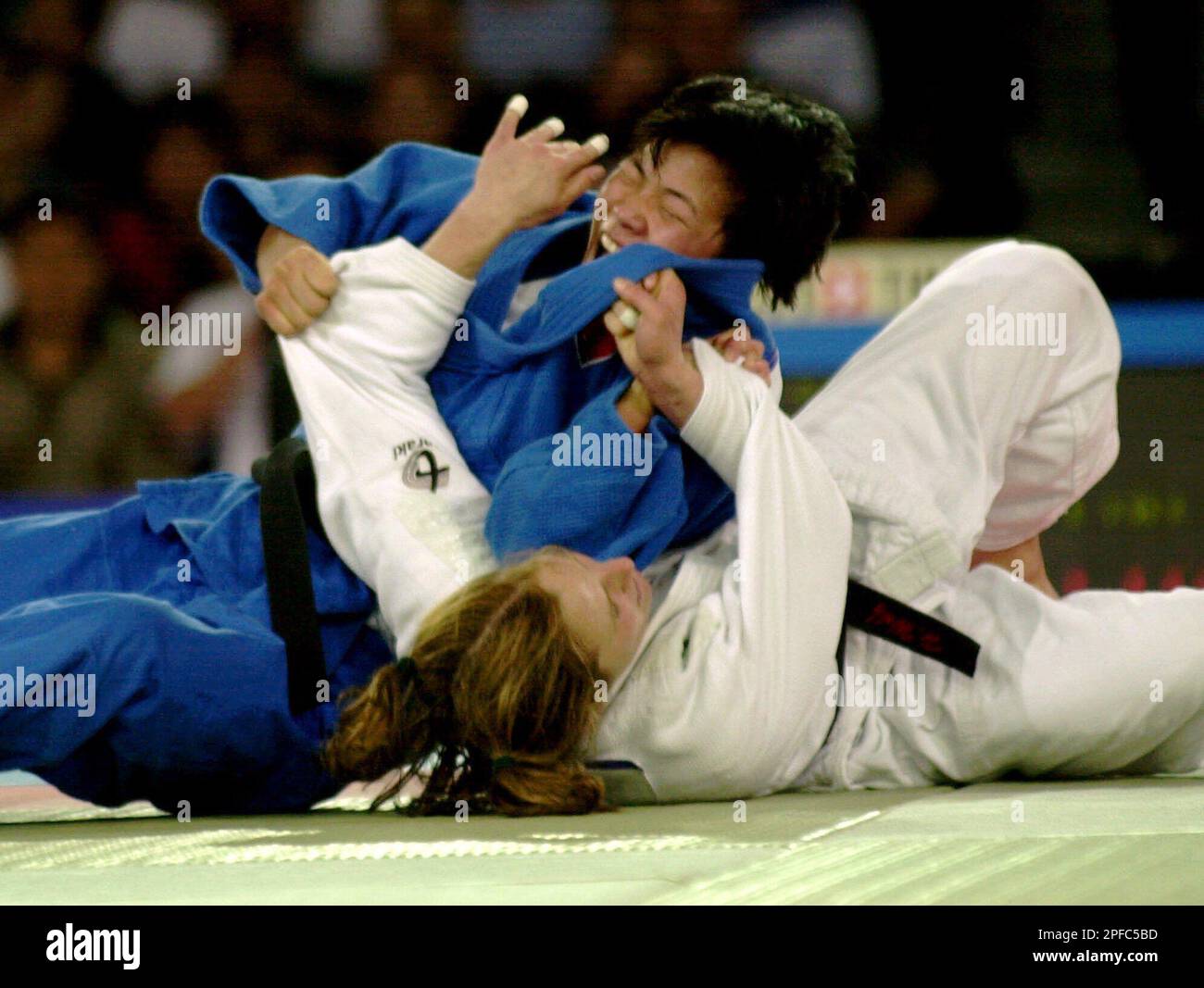 Korea's Sun Hui Kye, in blue, tries to pin down USA's ...