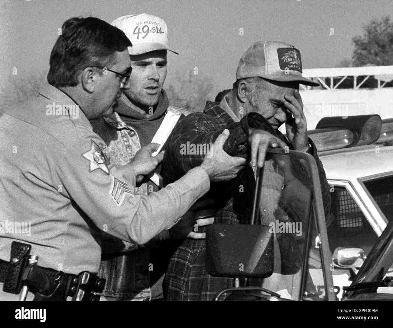 Merced County Sheriff Sgt. Gary Carlson, left, and Cary Stayner, center, comfort Delbert Stayner