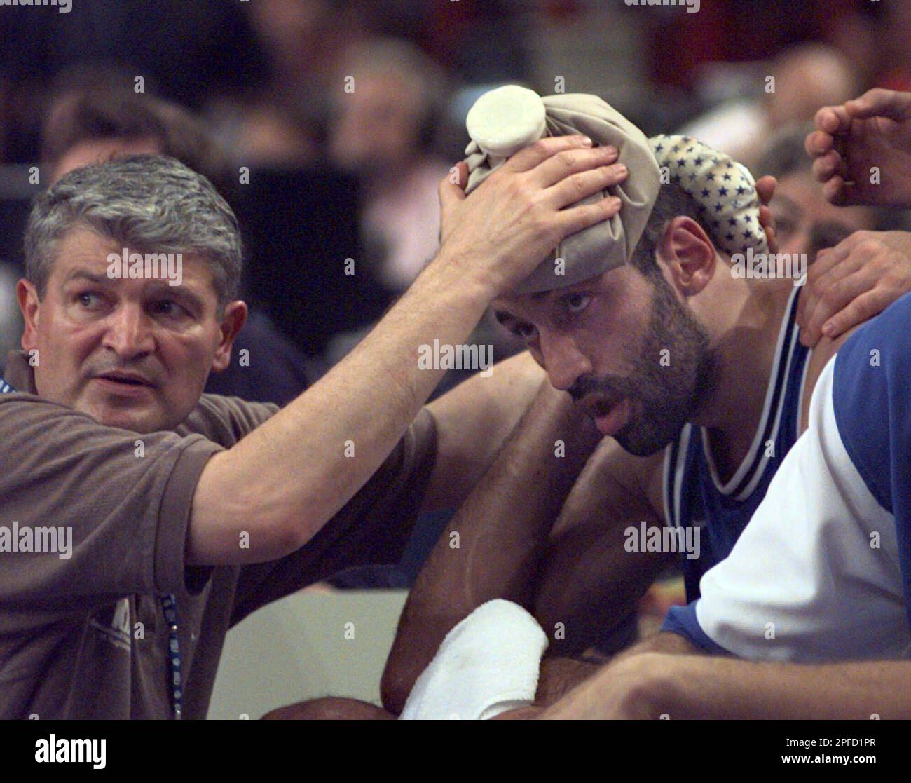 Yugoslavia's team doctor keeps ice on his player Vlade Divac, of the NBA's  Sacramento Kings, during the match for the third place against France at  the European Basketball Championship in Paris Saturday,