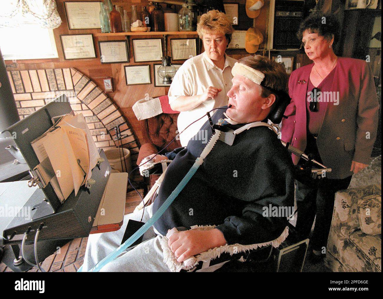 Steve Brewer turns a book page with a device called the Page Turner, as