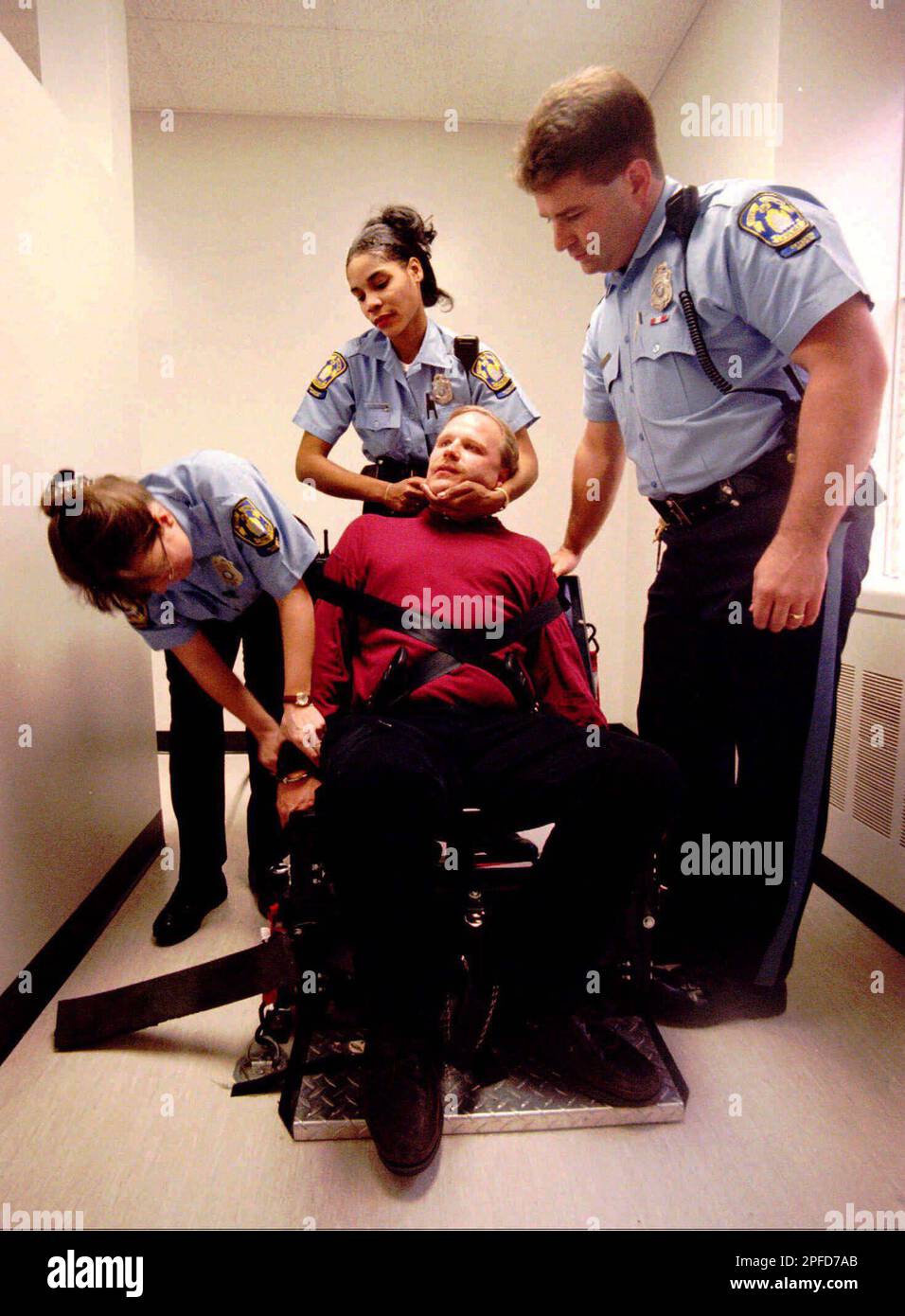 Lt. Chris Magnus is placed into a restraint chair by jail officers in