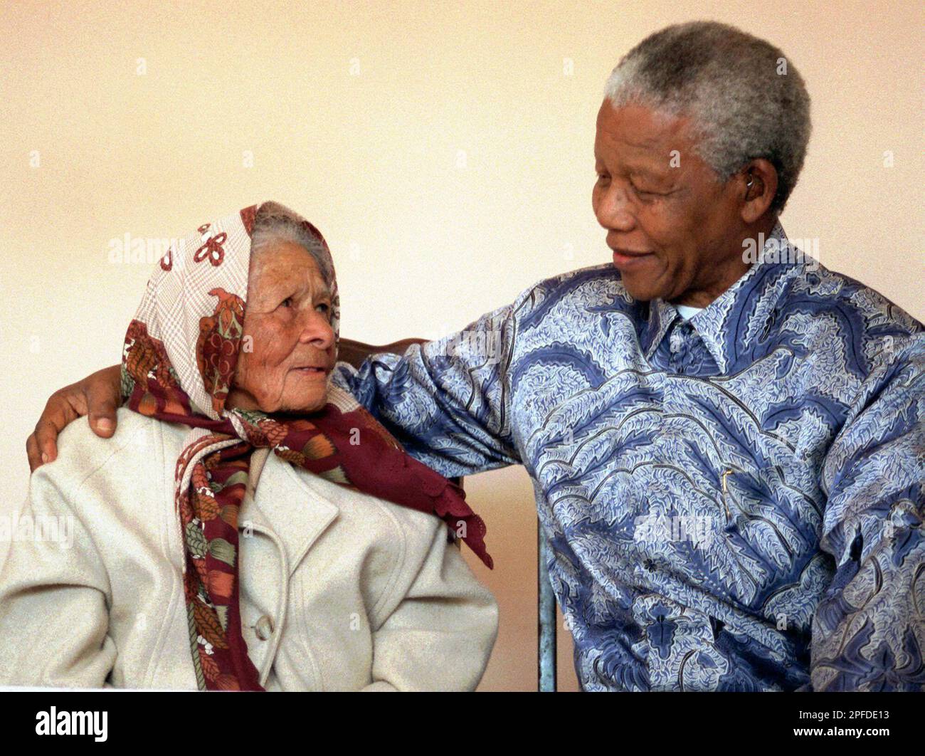 South African President Nelson Mandela, rights pays homage as he visits  96-year-old Augusta Lollan, left, at her home in Soweto, Tuesday June 30,  1998. Forty years ago Mandela used to meet fellow