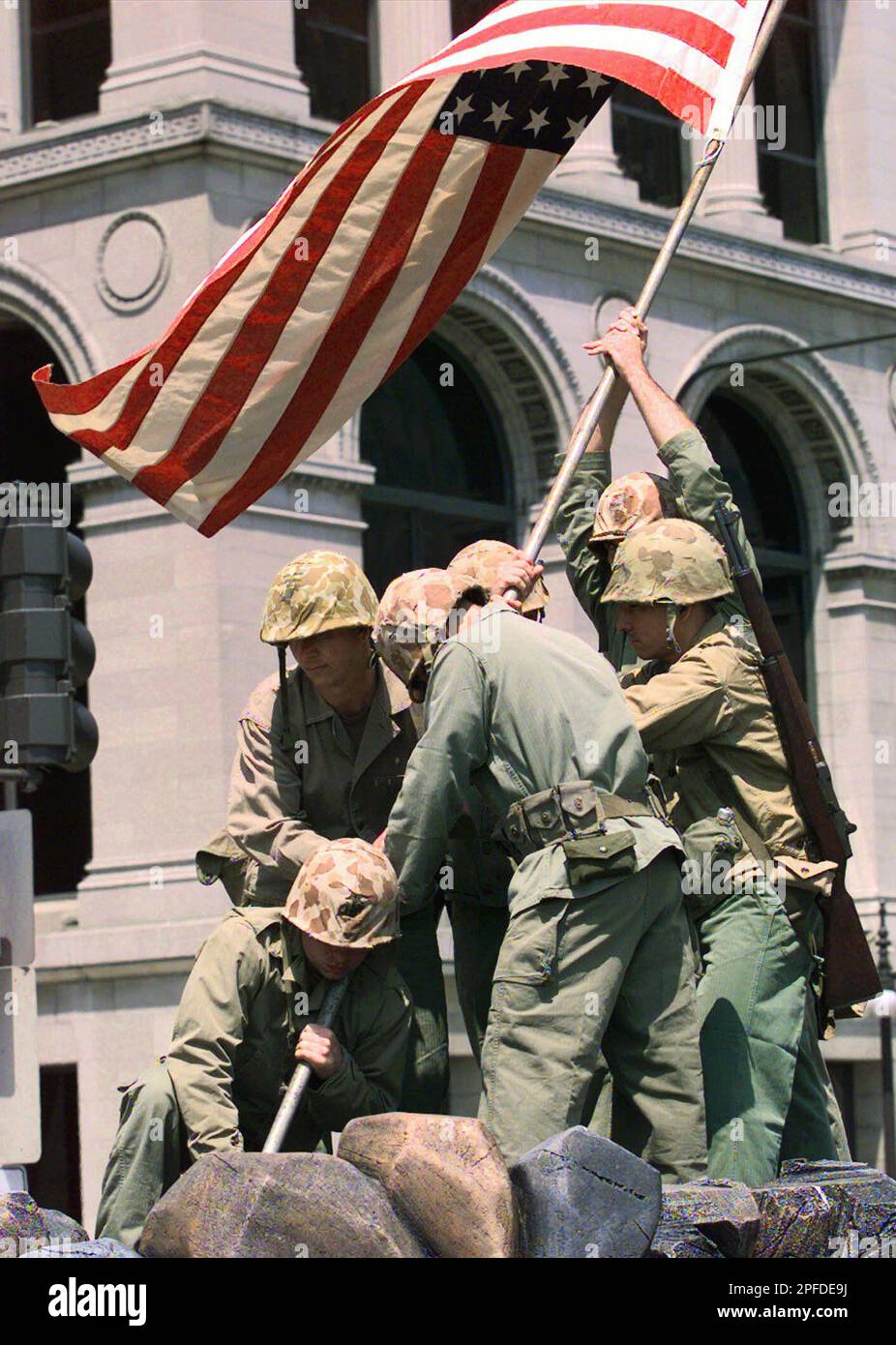 Soldiers re-enact the raising of the flag at Iwo Jima, an image made ...
