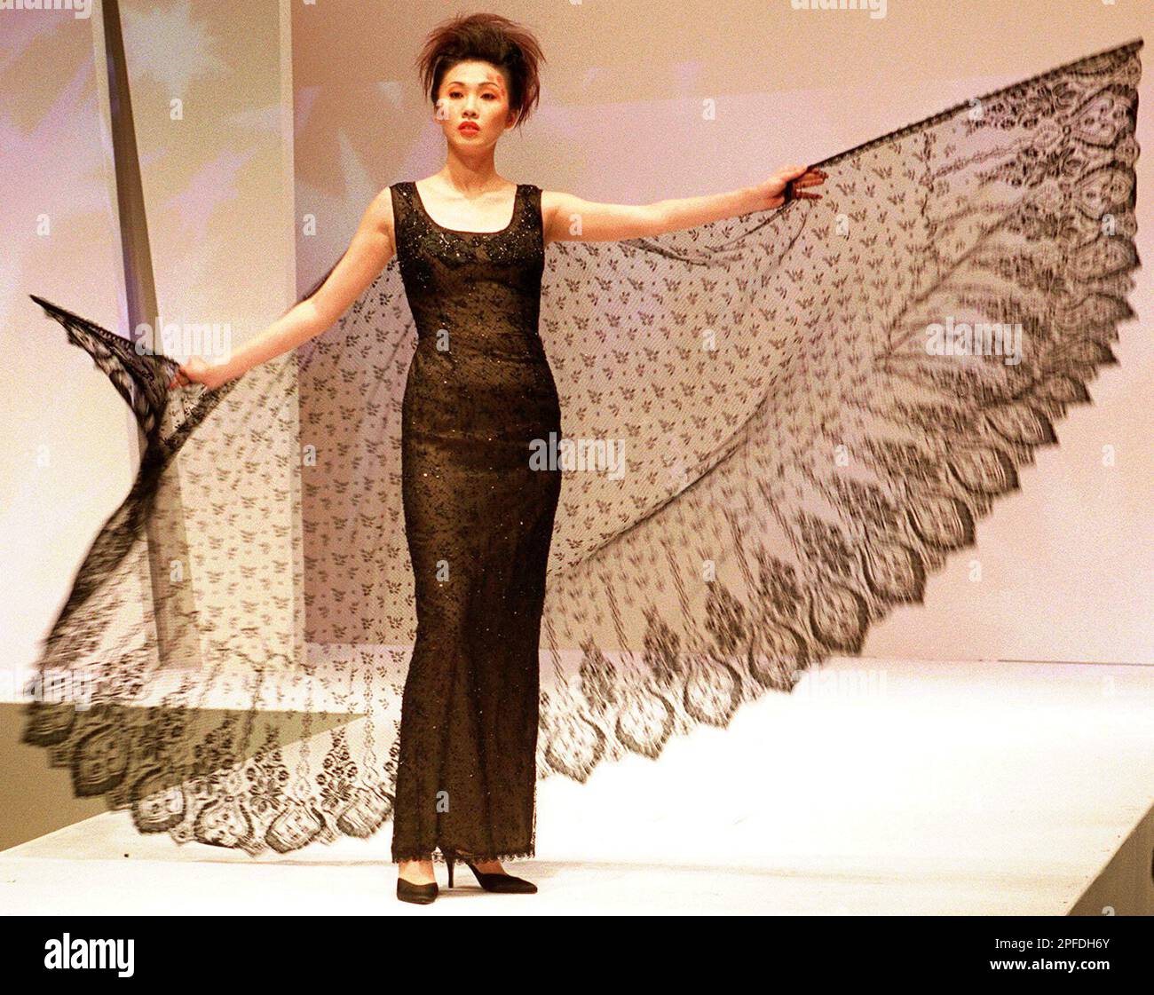 A model displays a long beaded evening gawn with a lace cape designed by Hong Kong designer Benny Yeung during the Asian Fashion Designers' Show, Friday, Jan. 16, 1988. Yeung's designs are A model displays a long beaded evening gawn with a lace cape designed by Hong Kong designer Benny Yeung during the Asian Fashion Designers' Show, Friday, Jan. 16, 1988. Yeung's designs are