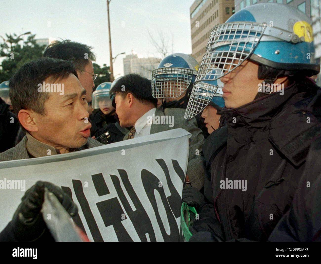 Riot police officers confront angry stock holders demanding that the ...
