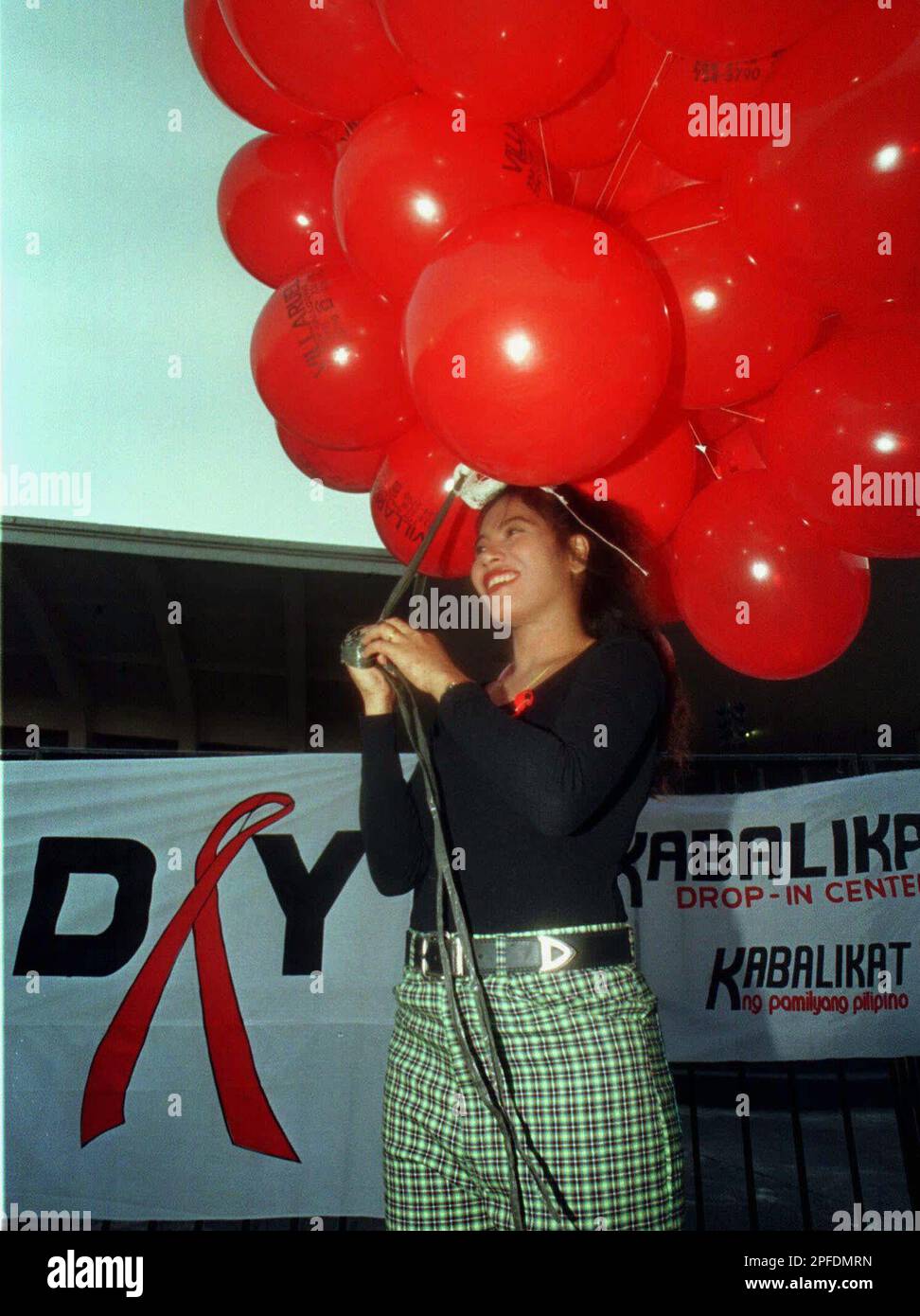 HIV positive Sarah Jane Salazar holds a bundle of red ballons during the  celebration of World AIDS Day Monday, Dec. 1, 1997 at the Luneta park in  Manila. Members of different health