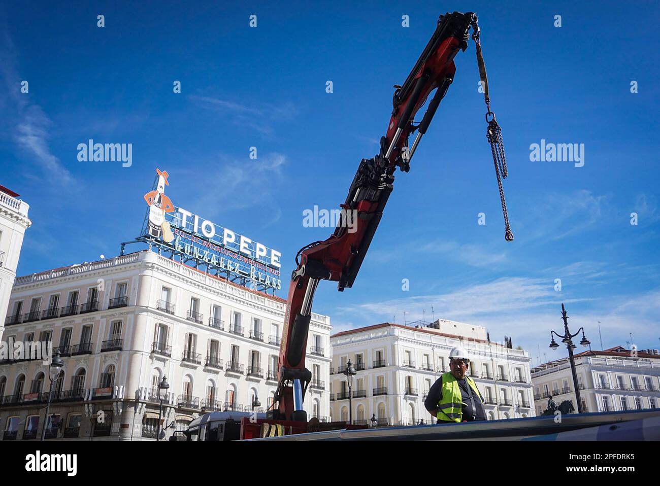 Madrid, Spain. 16th Mar, 2023. A worker drives a crane with the Tio Pepe advertising sign on his back during the rehabilitation works at Puerta del Sol. The works that are being carried out in Madrid's Puerta del Sol and that began in January 2022 are expected to be finished by the end of March. Credit: SOPA Images Limited/Alamy Live News Stock Photo