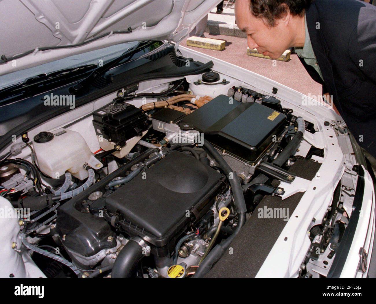 An economic journalist inspects the engine room of a car at Toyota ...