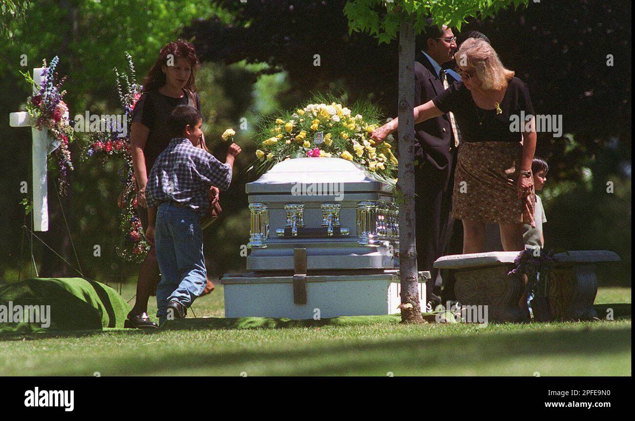 Family members leave flowers on the casket of Anthony Michael