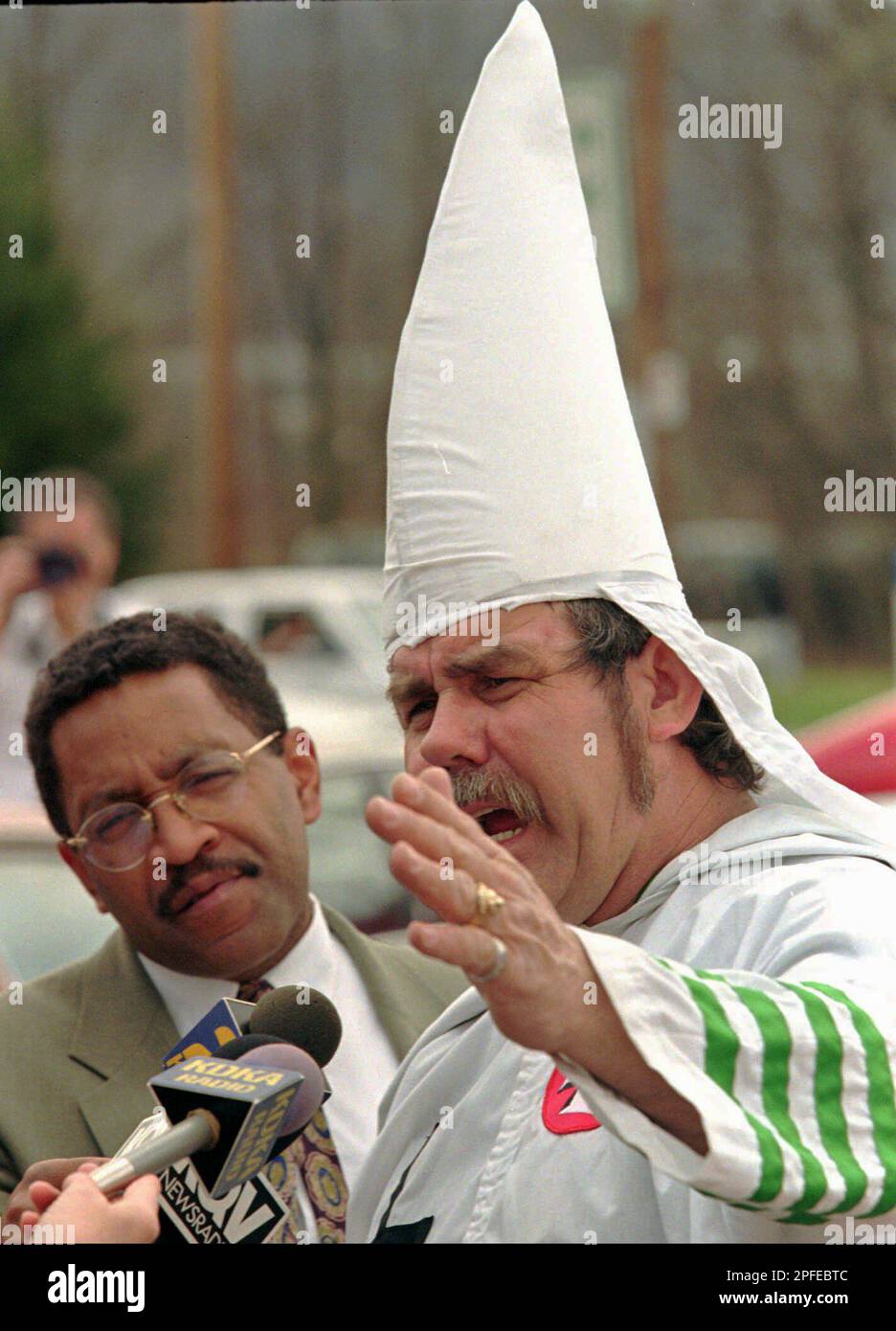 Harold Hayes left a newsman from KDKA TV in Pittsburgh listens as