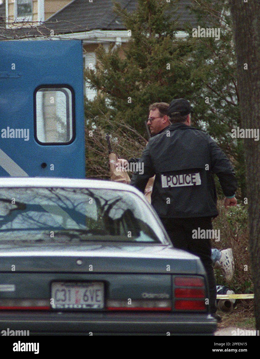 Police gathering evidence are seen outside the house in Eastchester, N
