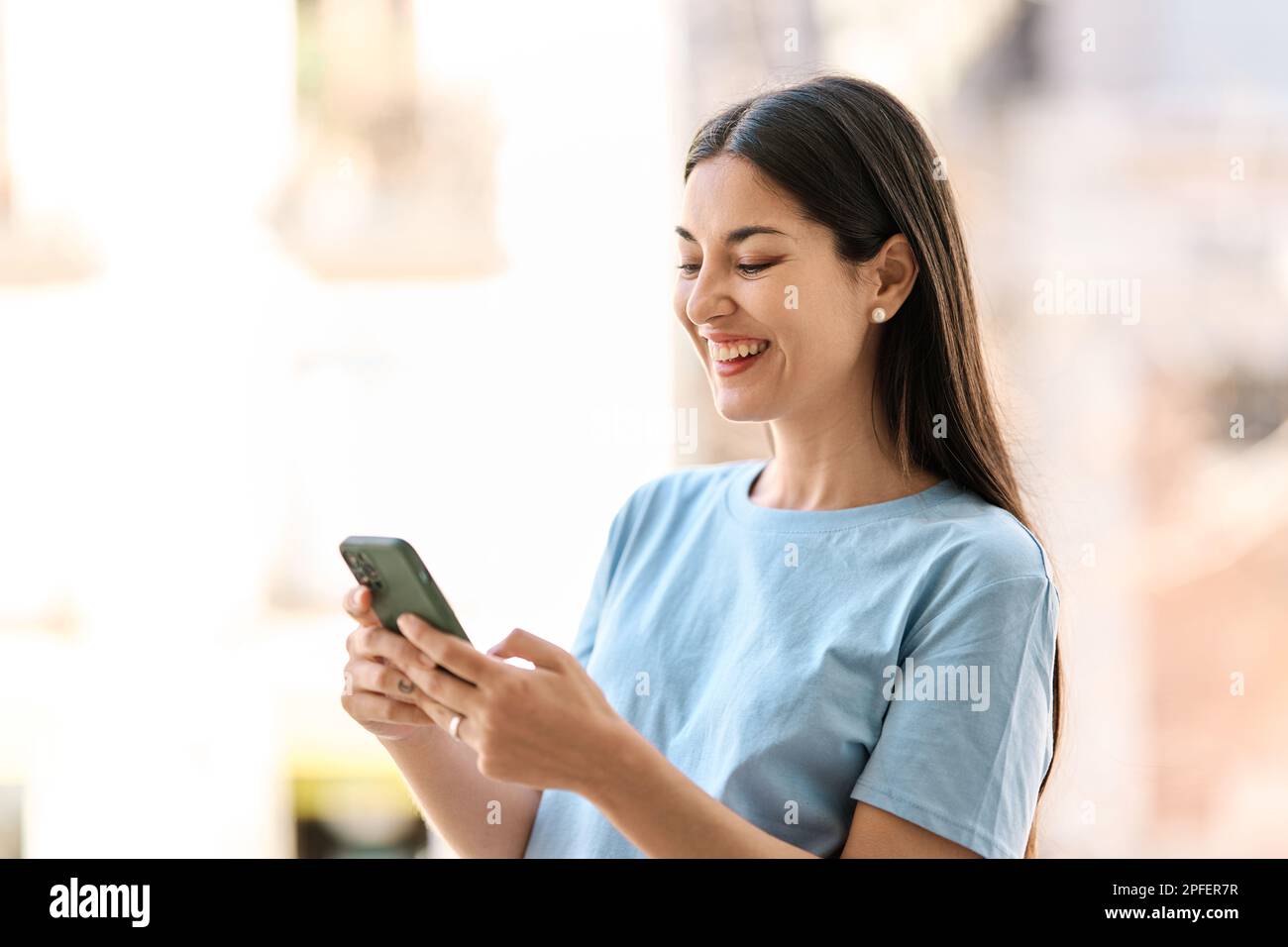 Happy woman using a mobile phone outdoors Stock Photo