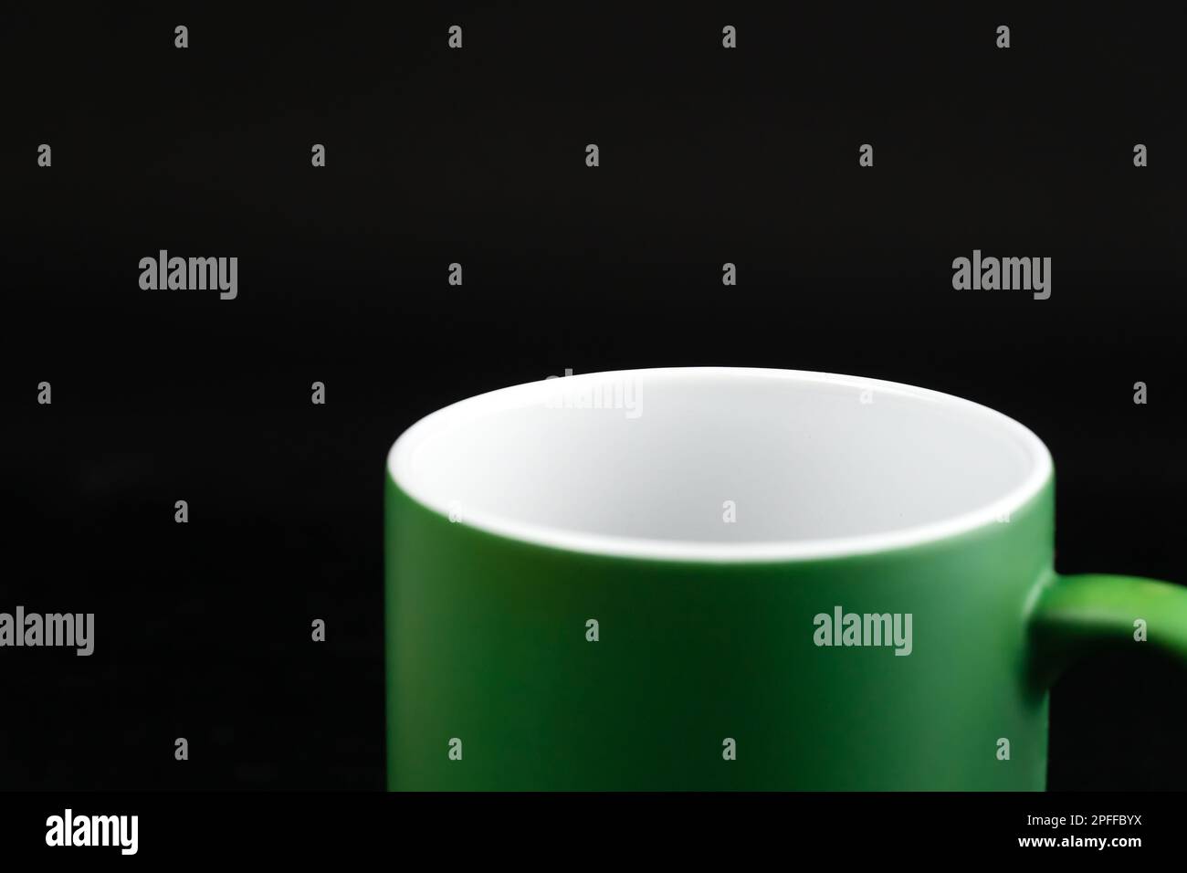 Empty green ceramic mug on a black background, macro photography Stock Photo