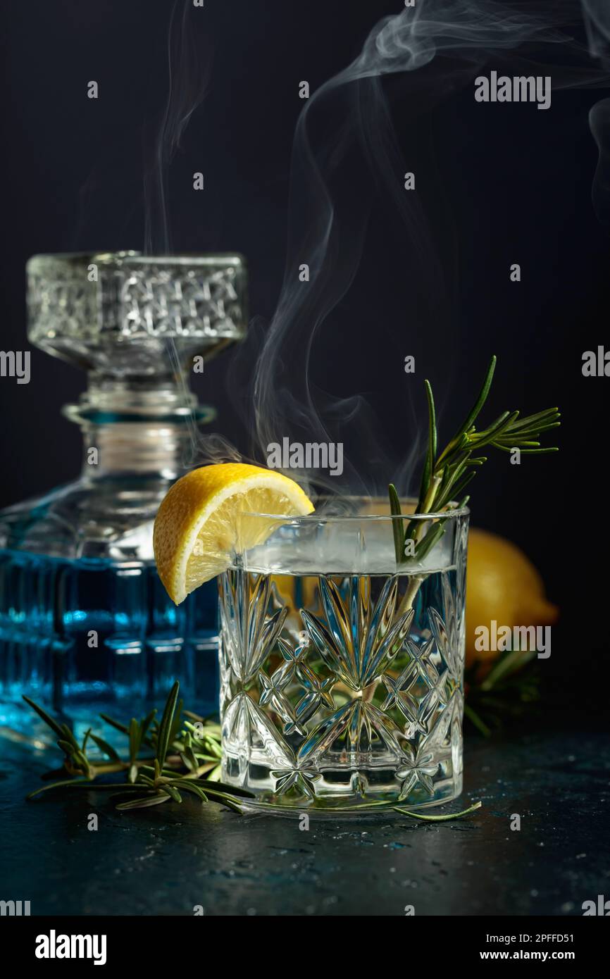 Cocktail Gintonic with lemon and rosemary in a crystal glass. Smoked