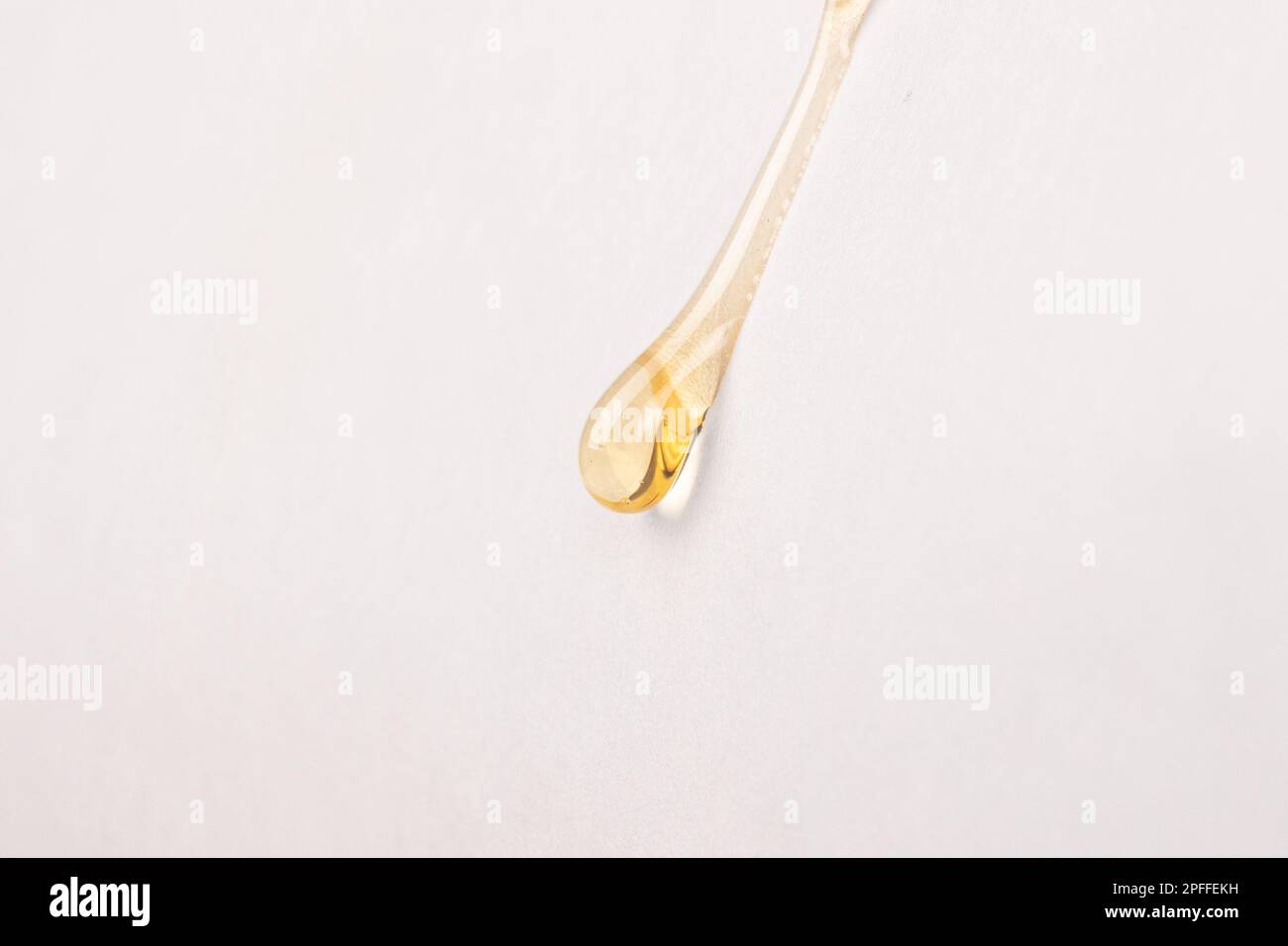 cannabis wax resin golden drop down on white paper closeup. Stock Photo