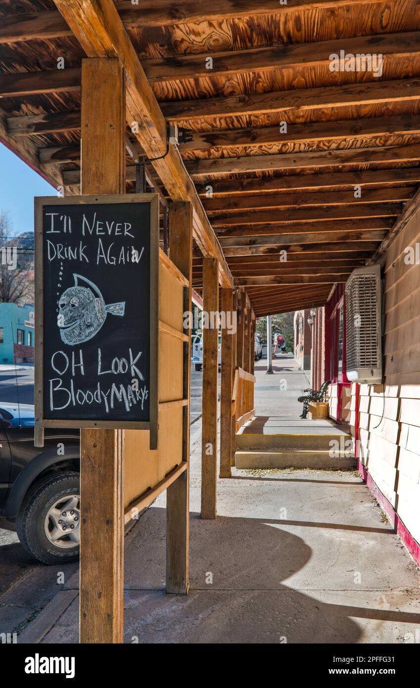 Humorous sign at saloon entrance, sidewalk porch, Main Street in