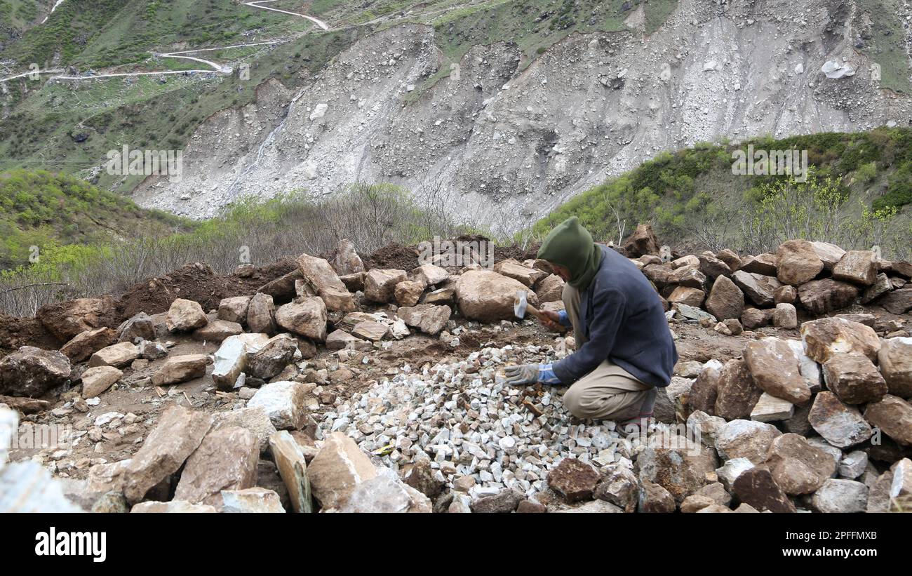 Rudarprayag, Uttarakhand, India, May 18 2014, A laborer breaking stones for the Kedarnath project. There is a reconstruction plan for the Kedarnath temple area that was damaged and significantly washed away in the Uttarakhand floods of 2013. Stock Photo
