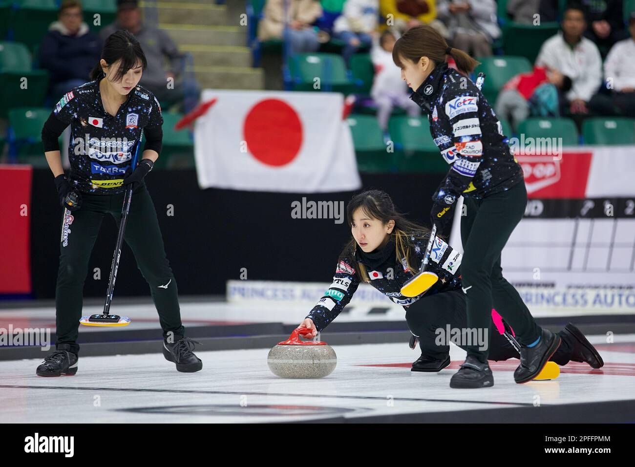 Satsuki Fujisawa delivers a stone with Japanese flag in the background during the final of the