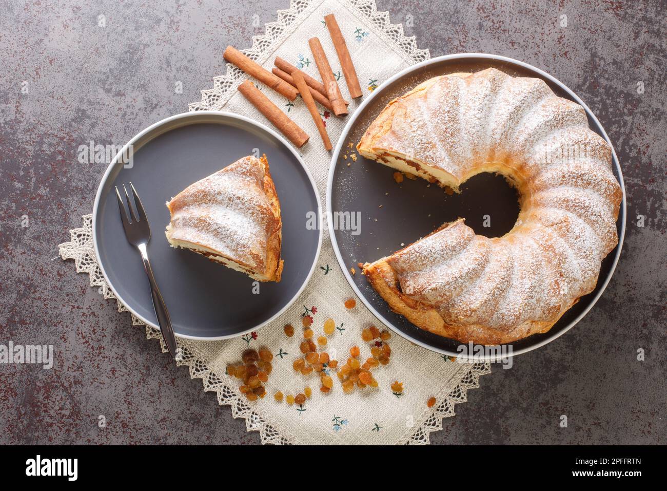 Homemade Easter Reindling cake with raisins and cinnamon close-up in a plate on the table. Horizontal top view from above Stock Photo
