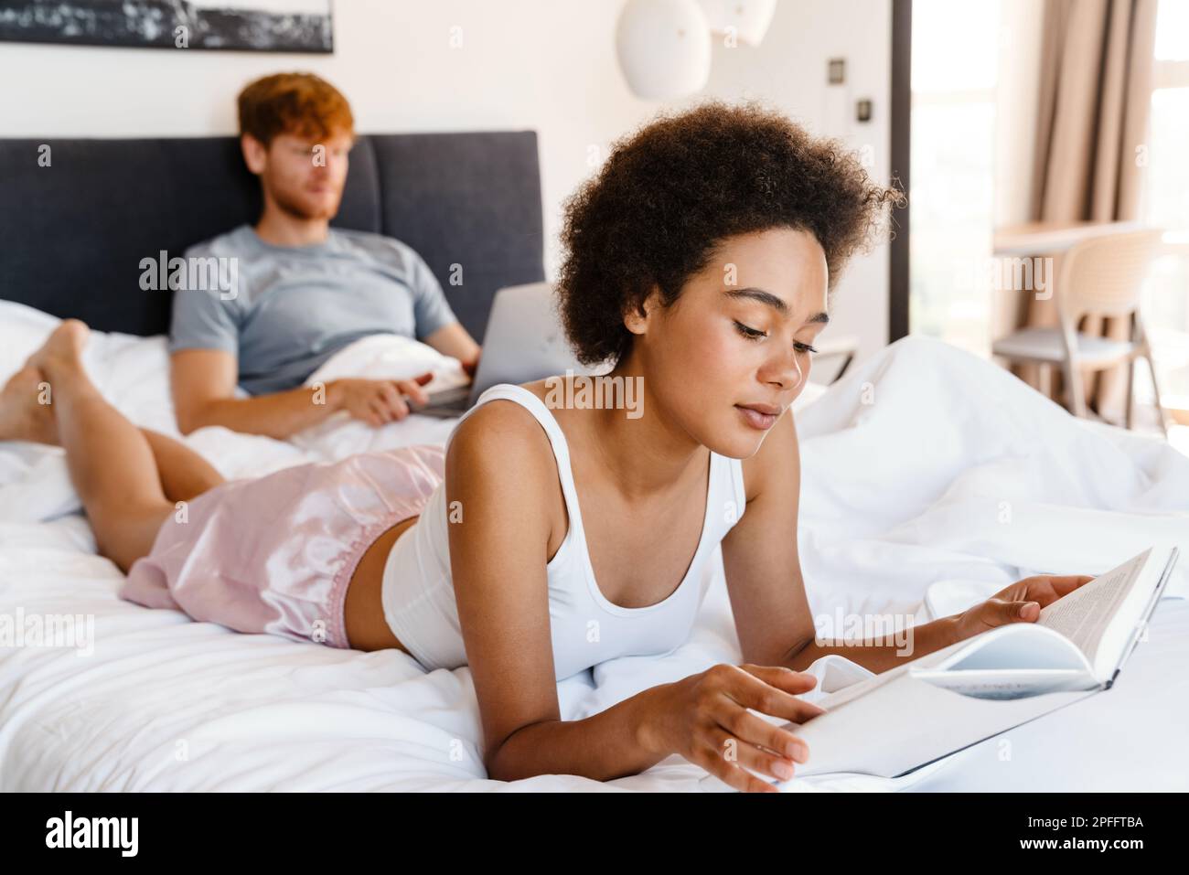 Beautiful african american young woman laying on bed in home