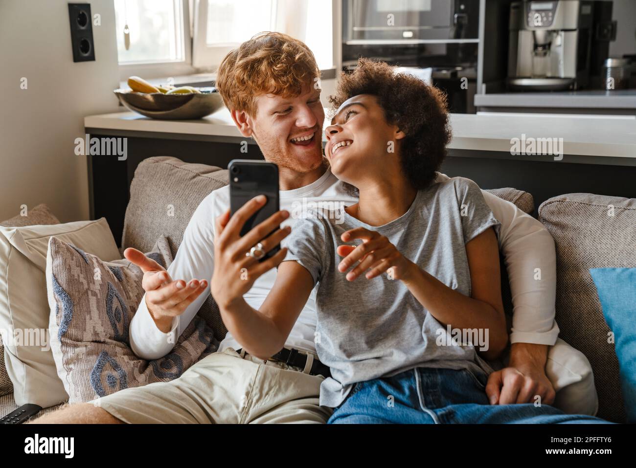 Young Handsome Redhead Happy Man Hugging His Beautiful Smiling African