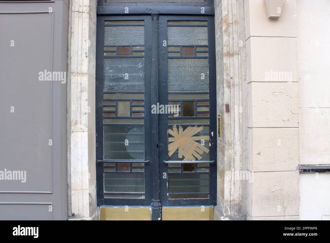 1930's art deco style vintage doorway with broken glass here located along the Boulevard Beaumarchais in Paris France. Stock Photo