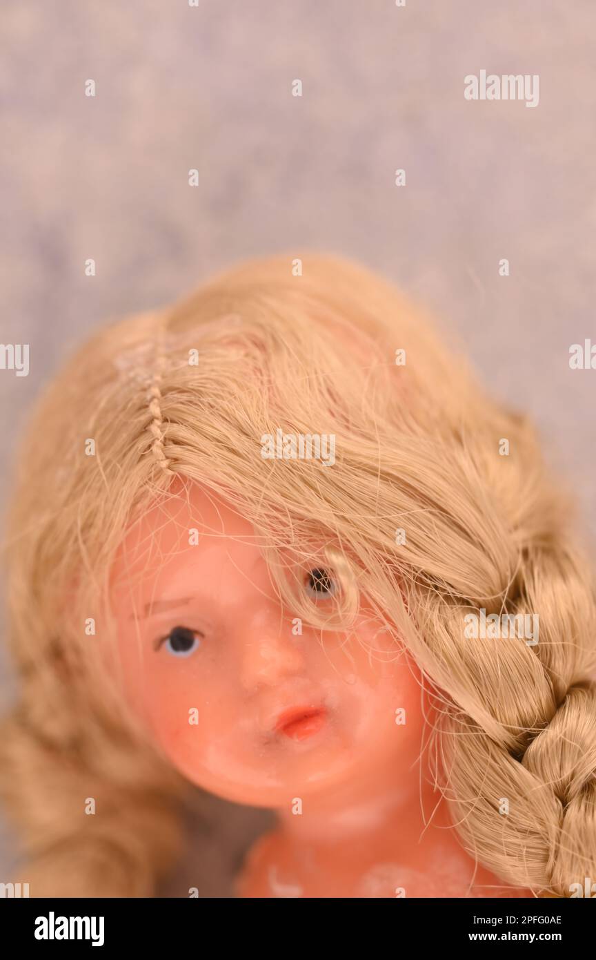 Head of 1970s girl doll with unruly plaited blond hair Stock Photo