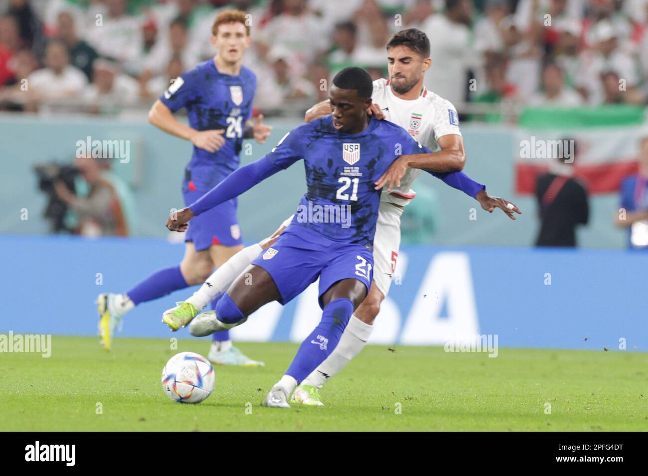 Timothy Weah of USA (L) and Milad Mohammadi (R) of Iran in action during the FIFA World Cup Qatar 2022 Match between IR Iran and USA at Al Thumama Stadium. Final score; IR Iran 0:1 USA. Stock Photo