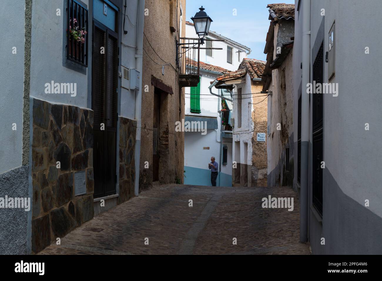 Streetscene of senior man walking in a street in the old centre of Guadalupe, Caceres province, Extremadura, Spain. Stock Photo