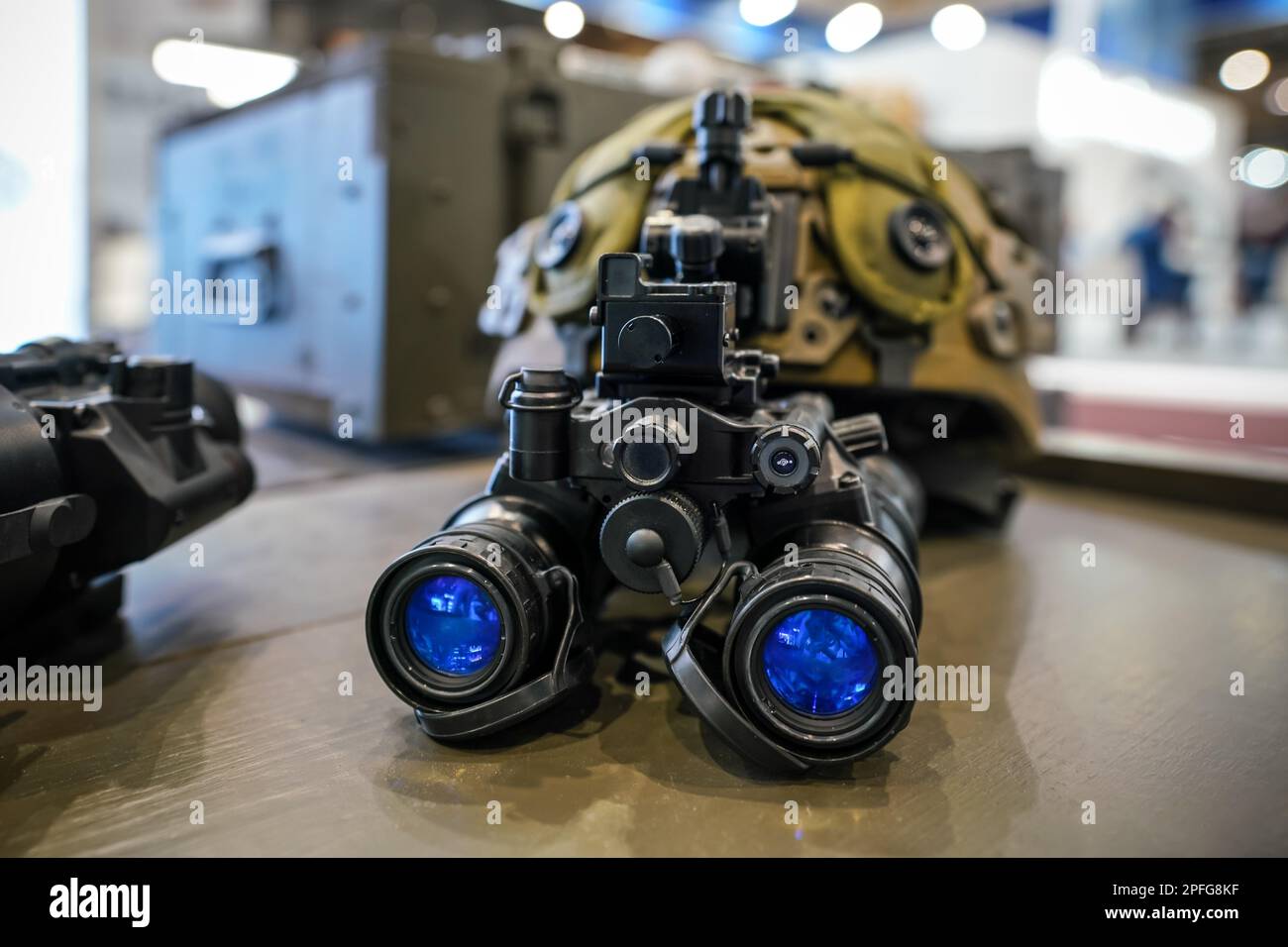 Night vision goggles on military helmet, closeup detail to blue reflective lenses Stock Photo