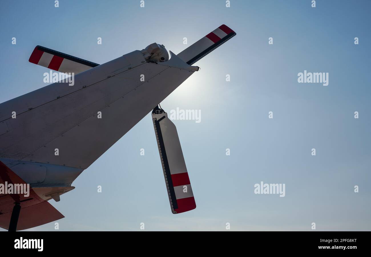 Looking up red and white rear helicopter rotor, bright sun background ...