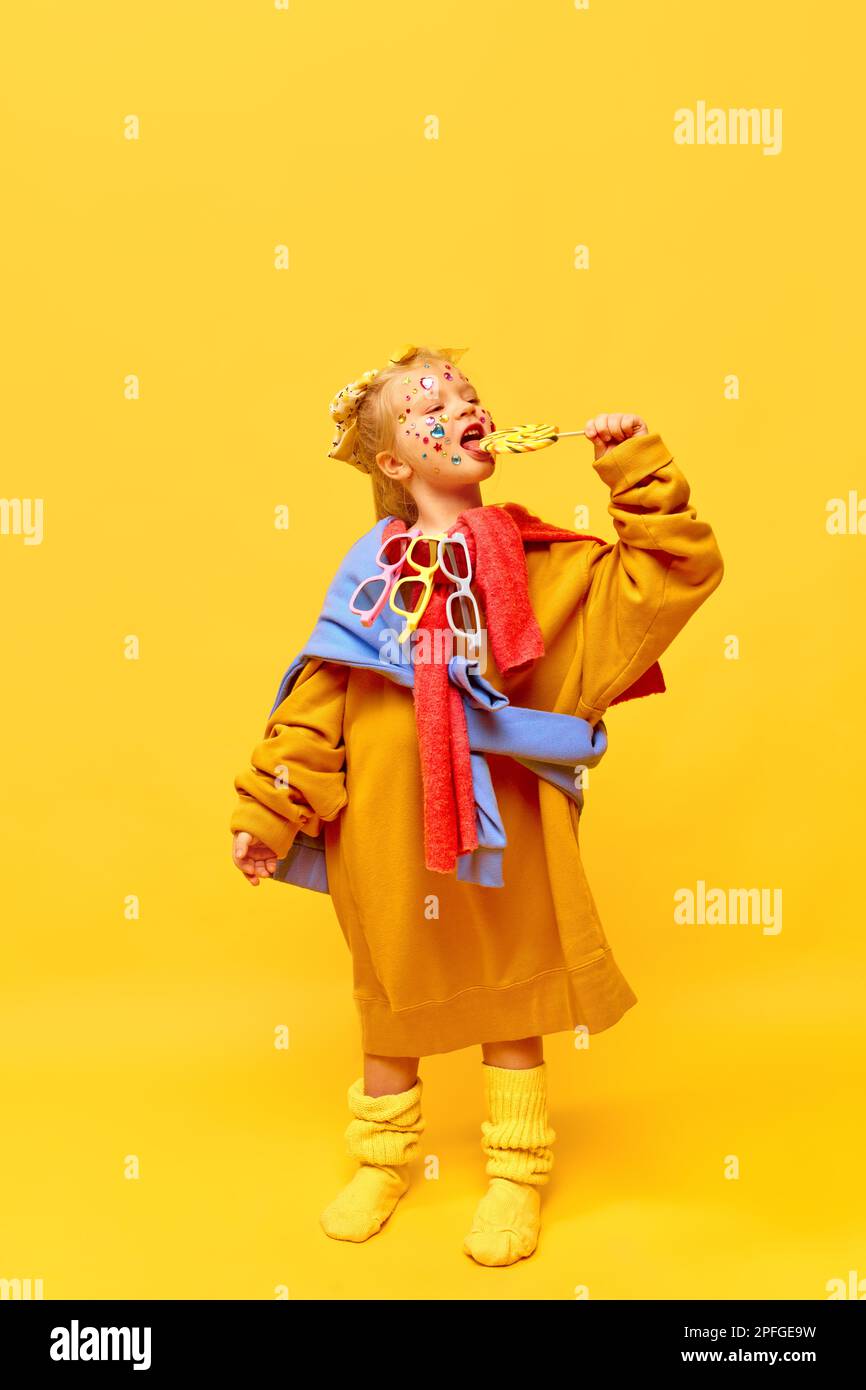 Fulllength photo of little girl wearing big clothes, smiling with