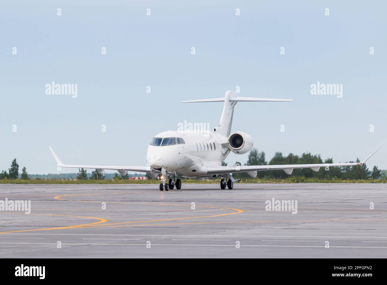 White luxury private jet taxiing on airport taxiway Stock Photo