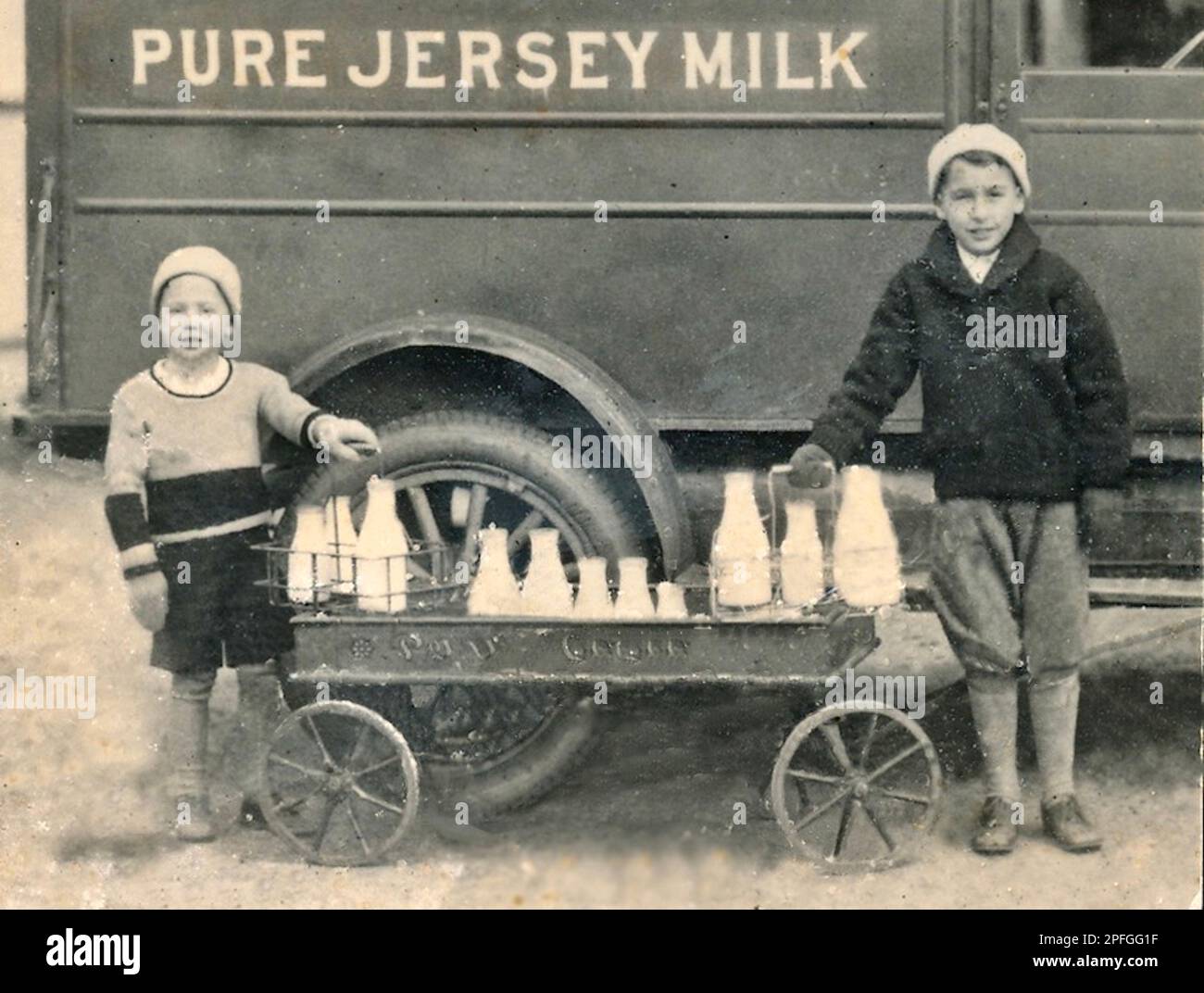 Old Milk Truck early 1900s, Boys selling Milk, Glass Bottles, Wagon, Old Fashioned Milk Truck Early 1900s Stock Photo