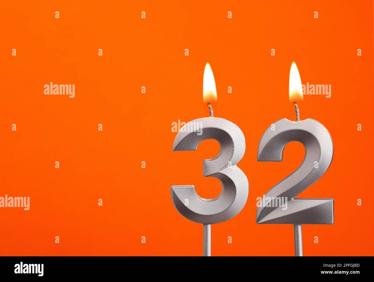 Candle number 32 - Birthday in orange background Stock Photo - Alamy