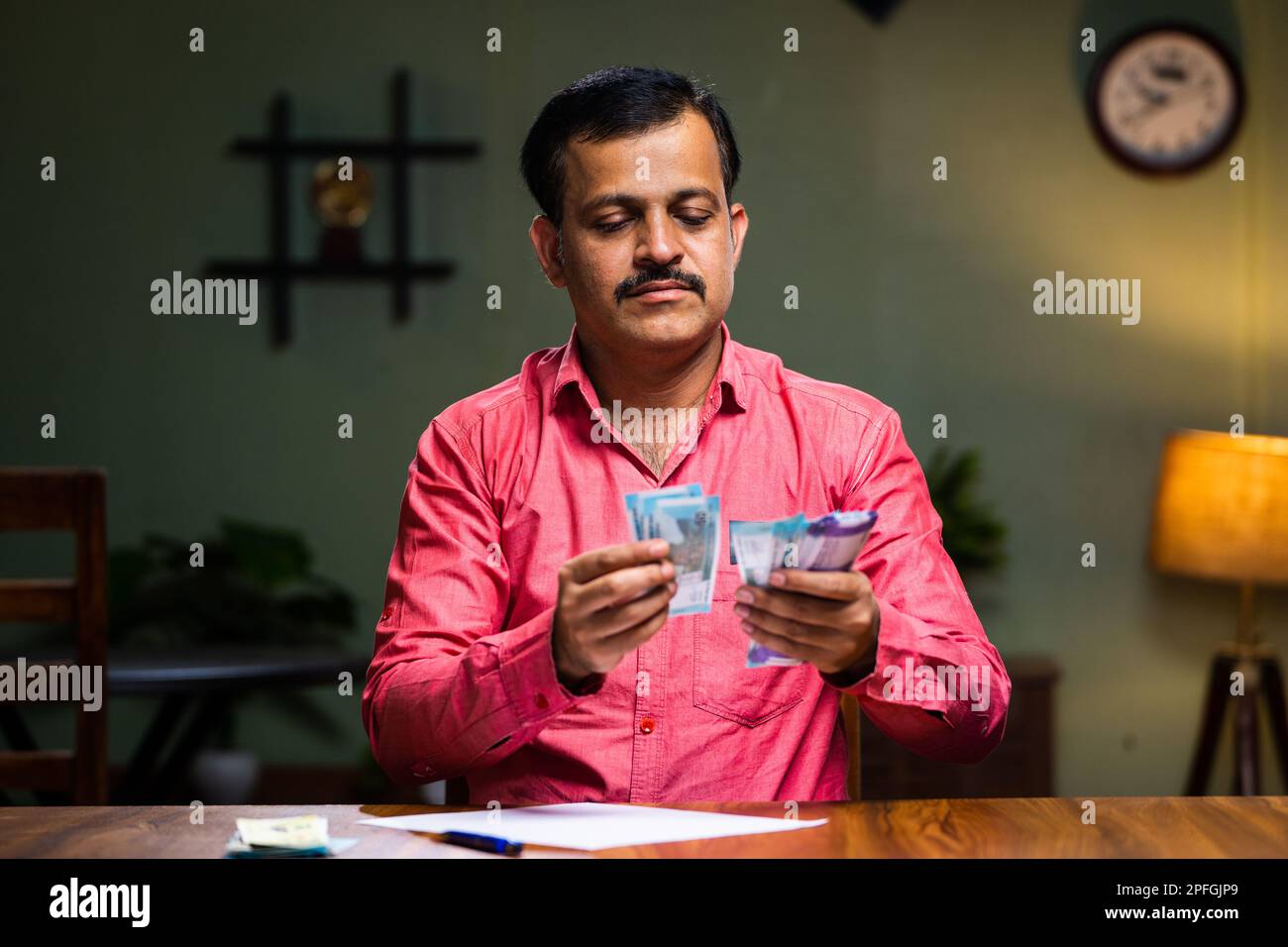 Middle aged family man doing monthly budget calculation after salary at home - concept of middle class lifestyle, savings and expenses planning. Stock Photo