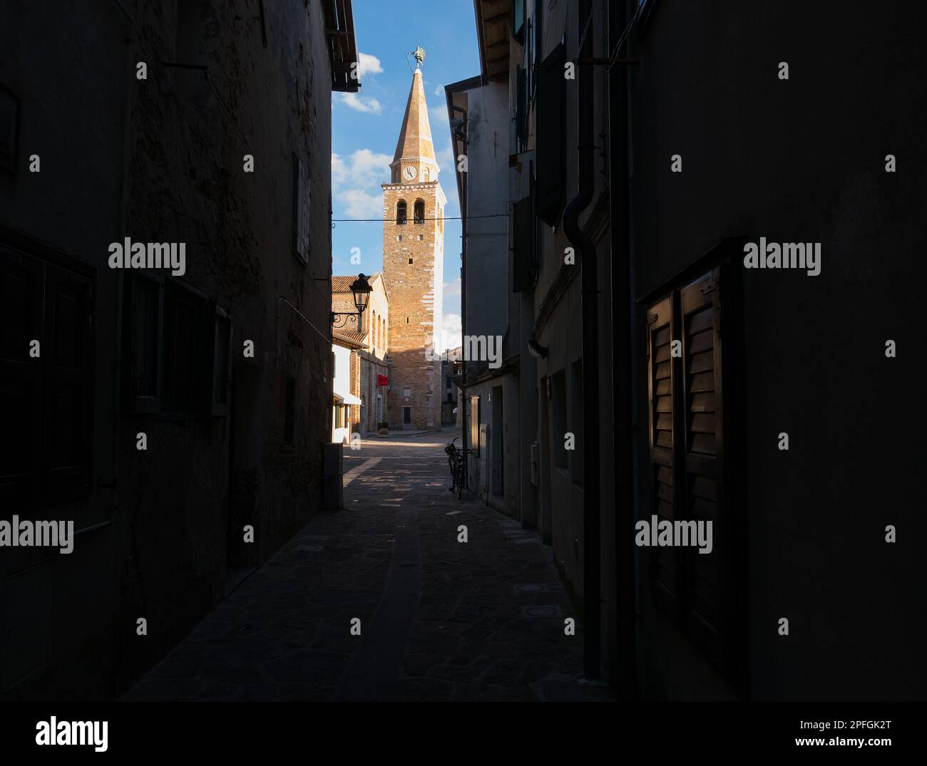 Grado, Italy - View of the bell tower of the ancient basilica at the end of antique and pictoresque alley Stock Photo