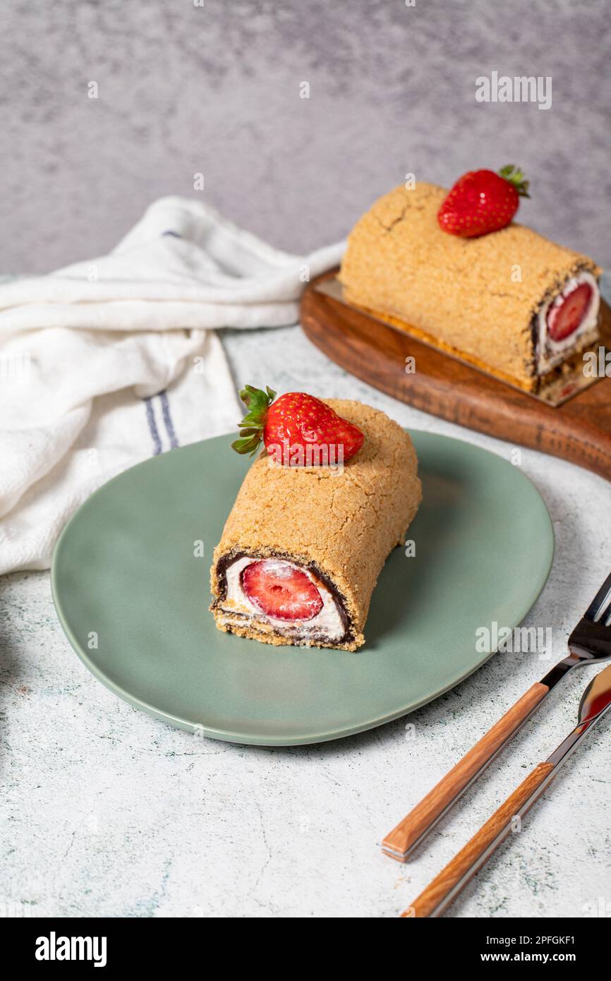 Rolled log cake. Strawberry and cream cake on a stone background. Patisserie desserts Stock Photo