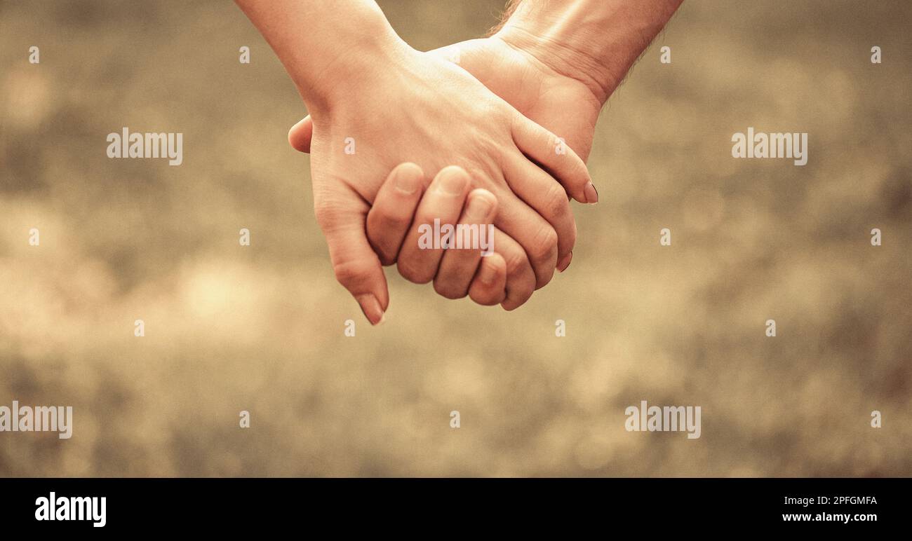 Couple hold hand in the autumn or summer park. Closeup of loving ...