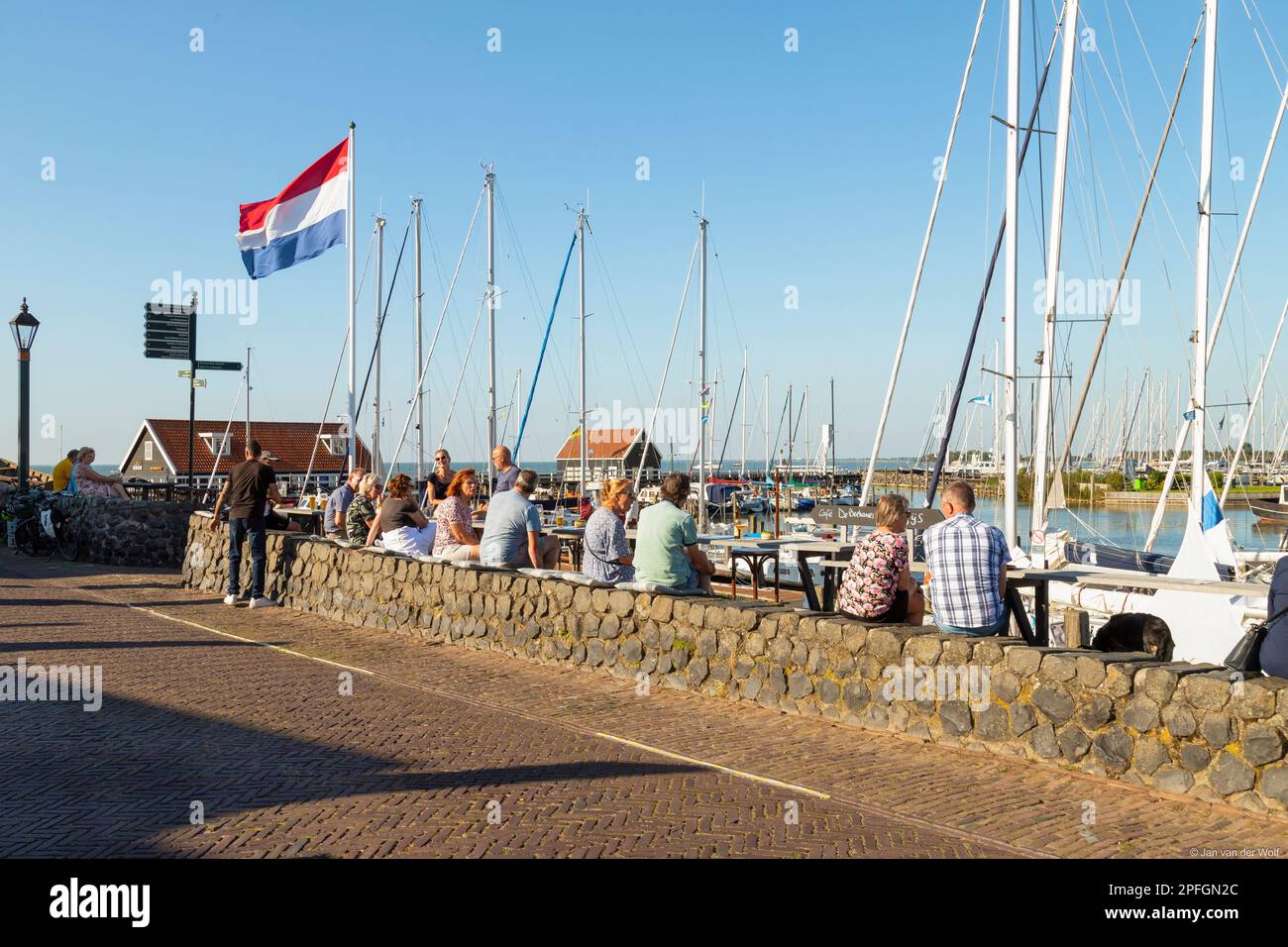 People enjoy the marina of the picturesque village of Hindeloopen in Friesland. Stock Photo