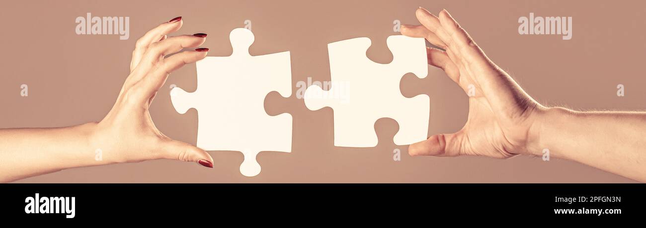 Two hands trying to connect couple puzzle piece on gray background ...