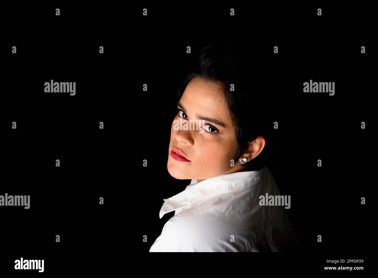 Young woman portrait in studio wearing white shirt. Isolated on black ...