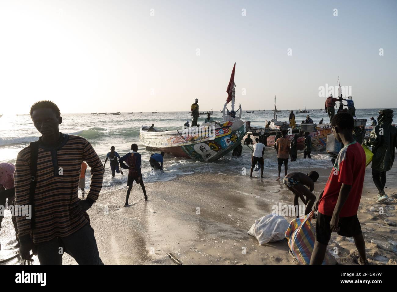 African fishermen unloading the day's catch of fish. Port de Peche, Nouakchott's famous fish market, plage des pecheurs. Mauritania. Stock Photo