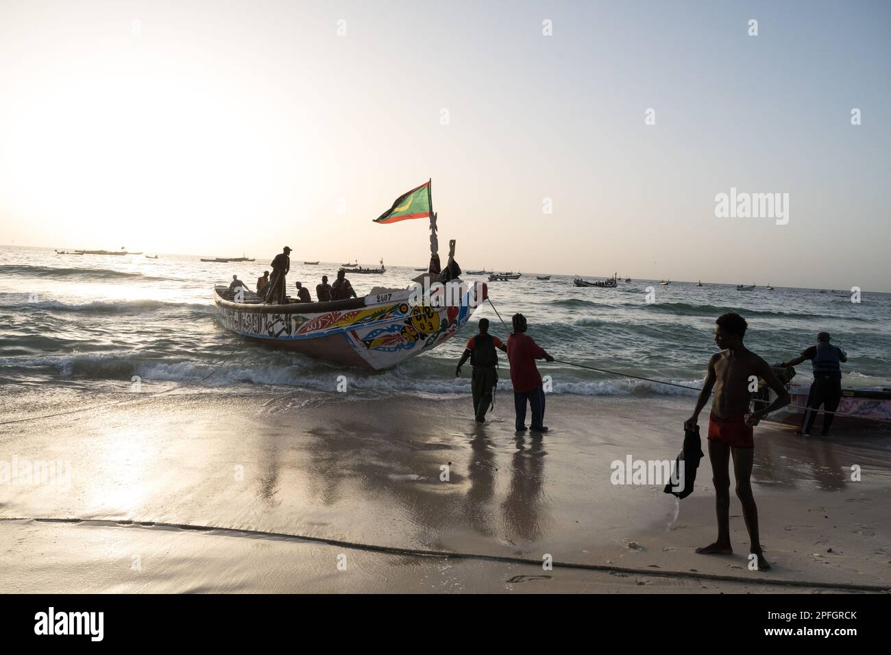 African fishermen unloading the day's catch of fish. Port de Peche, Nouakchott's famous fish market, plage des pecheurs. Mauritania. Stock Photo