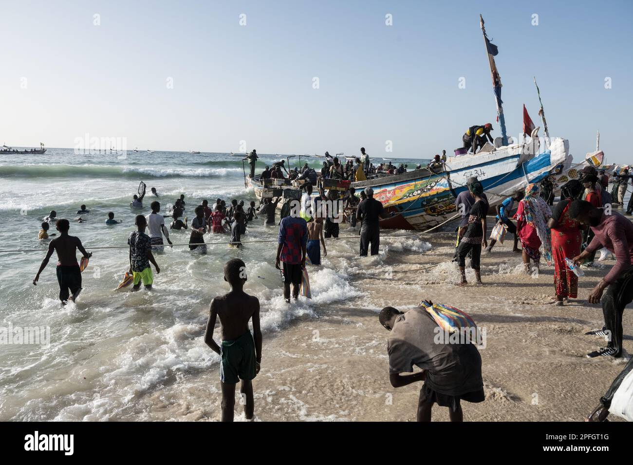African fishermen unloading the day's catch of fish. Port de Peche, Nouakchott's famous fish market, plage des pecheurs. Mauritania. Stock Photo