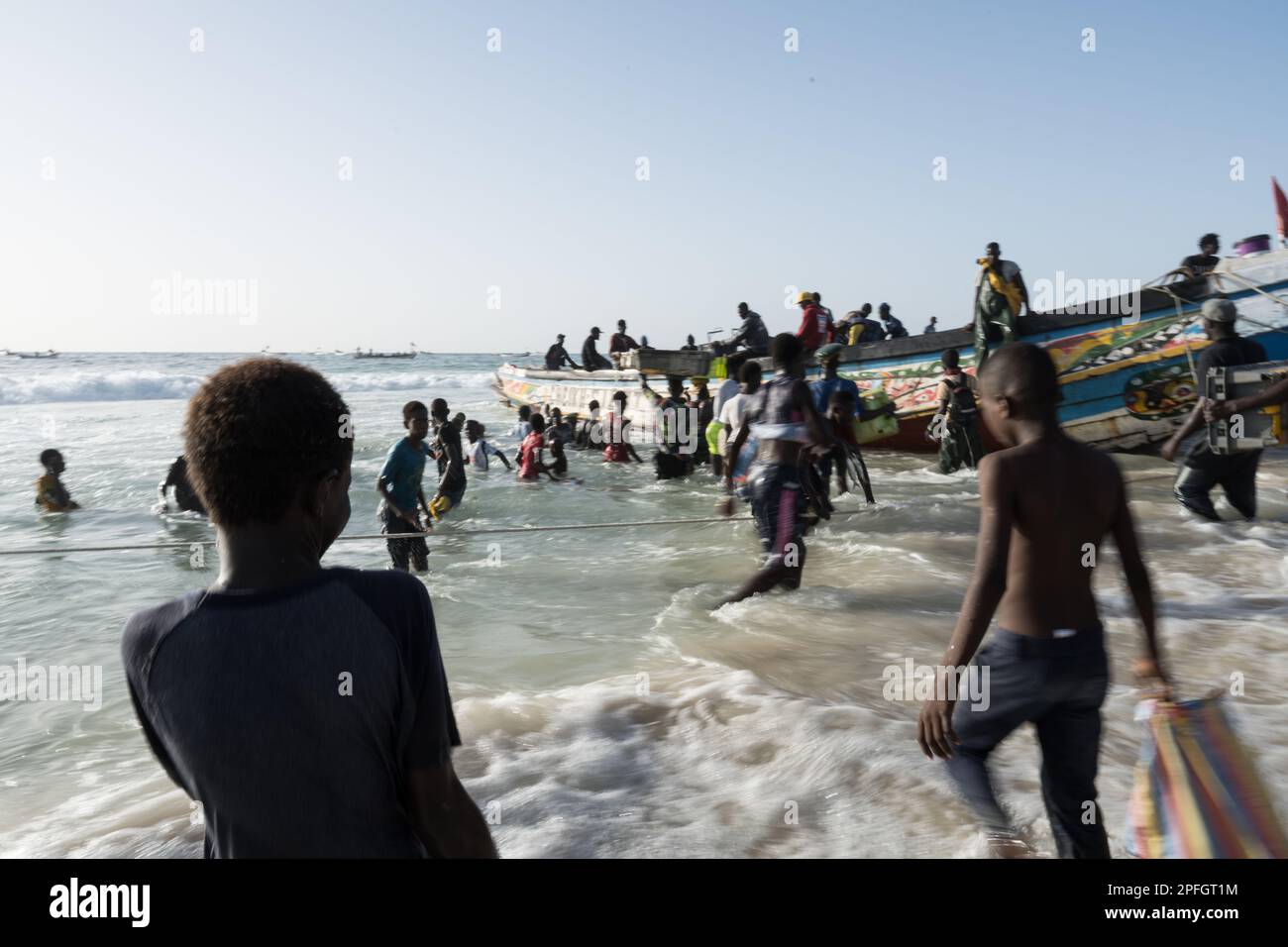 African fishermen unloading the day's catch of fish. Port de Peche, Nouakchott's famous fish market, plage des pecheurs. Mauritania. Stock Photo