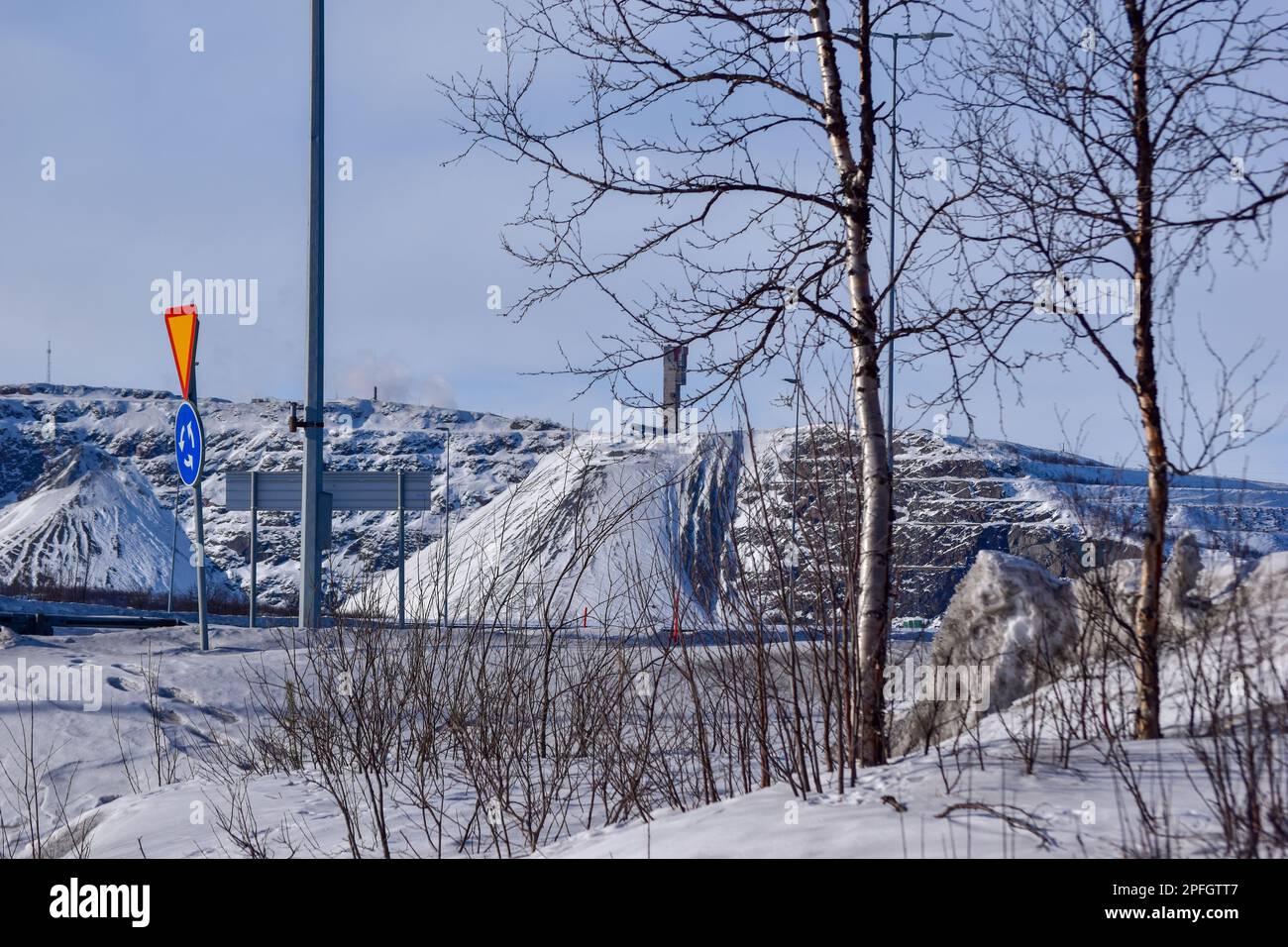 View of Kiruna city and the iron ore mine on the mountain Kiirunavaara seen from the snowy mountain peak Luossavaara. Stock Photo