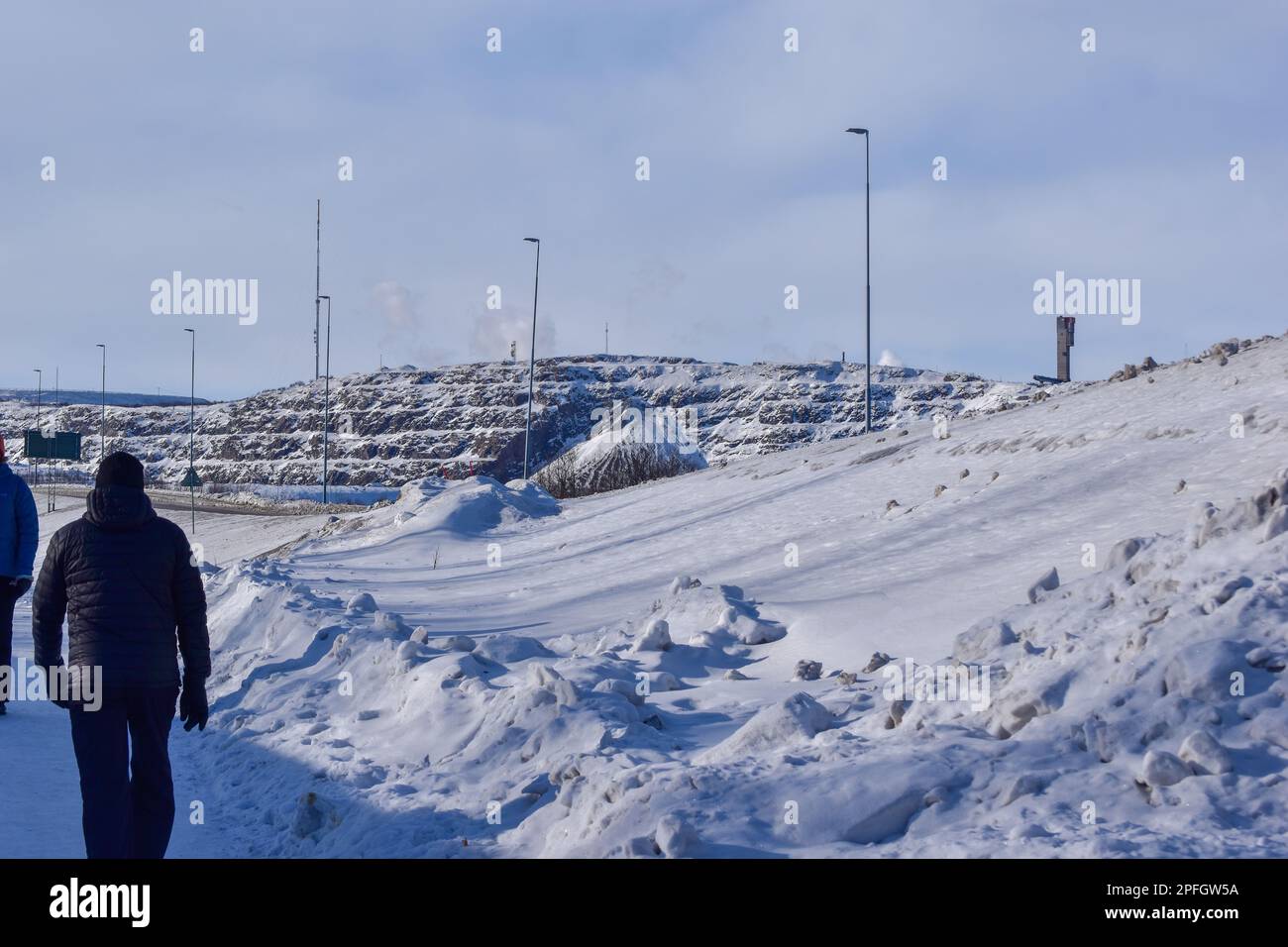 View of Kiruna city and the iron ore mine on the mountain Kiirunavaara seen from the snowy mountain peak Luossavaara. Stock Photo