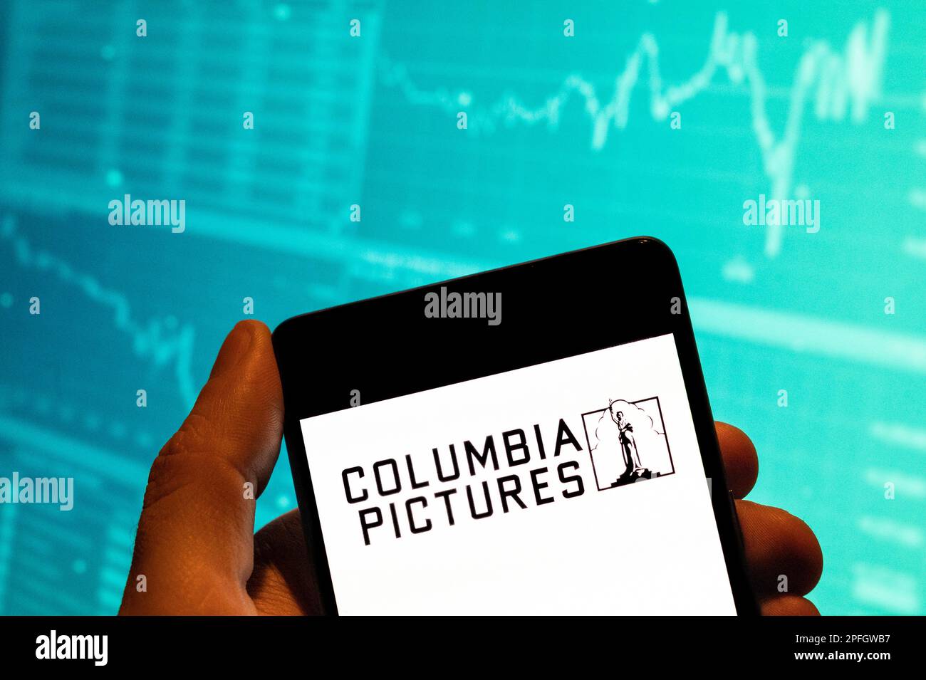 China. 15th Feb, 2023. In this photo illustration, the American film studio, production company, and film distributor Columbia Pictures logo is seen displayed on a smartphone with an economic stock exchange index graph in the background. (Credit Image: © Budrul Chukrut/SOPA Images via ZUMA Press Wire) EDITORIAL USAGE ONLY! Not for Commercial USAGE! Stock Photo